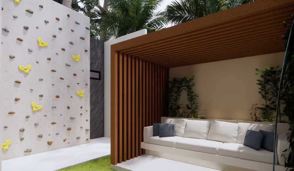 Halaman belakang GA House dengan dinding panjat anak, gazebo modern kayu, dan area rumput hijau.