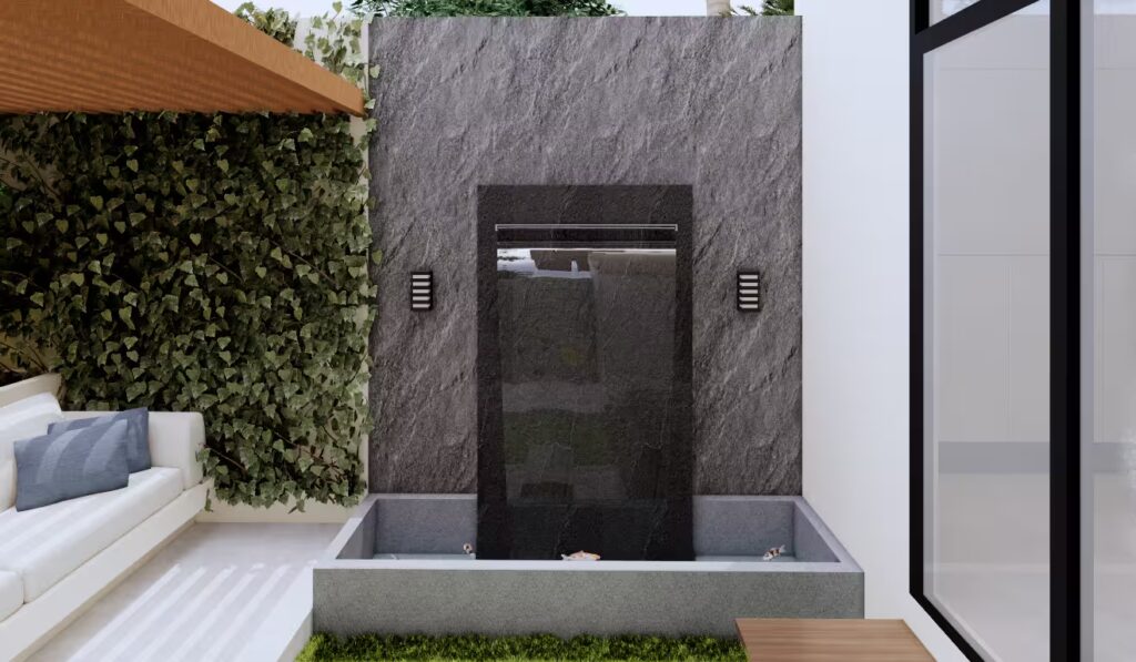 Dinding air terjun GA House dengan finishing batu alam gelap, kolam ikan koi minimalis, dan tanaman rambat.