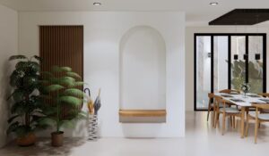 Area foyer rumah Mr. AM dengan desain interior minimalis modern, menampilkan dinding lengkung, tanaman hias, dan akses menuju ruang makan terbuka.
