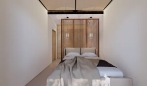 Area tempat tidur kamar utama rumah Mr. AM dengan panel kisi kayu vertikal dan lampu gantung simetris yang menonjolkan kesan hangat dan elegan.
