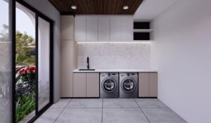 Ruang servis dengan dua mesin cuci, kabinet minimalis, dan bukaan kaca menuju area taman.