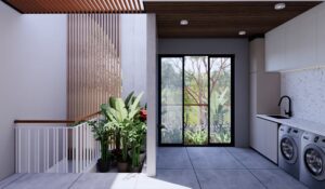Taman kering kecil dengan tanaman pot dan pencahayaan natural dari void.”