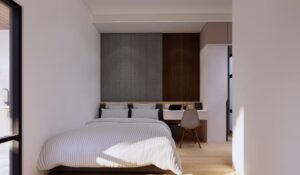 Kamar anak dengan ranjang double dan meja belajar di depan panel dinding kayu.