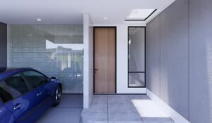 Area entrance dengan pintu kayu, kaca besar, dan cahaya dari skylight di atas.