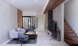 Ruang keluarga dengan sofa lembut, TV wall panel, dan tangga kayu di sisi kanan.